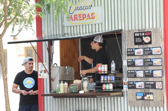 Carlos and Luis at the Caracas cart, one at the window and one serving out front